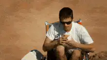 Man eating on a beach chair zooms out