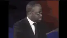 African man in suit looking down then up