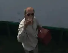 man points at camera then mows lawn