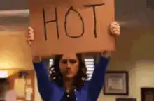 Woman holding a sign that says HOT