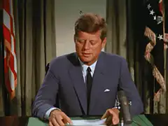 John F. Kennedy scratches his chest
