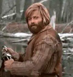 Man with beard smirking in forest