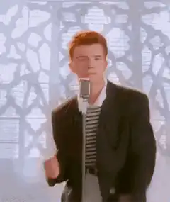 Rick Astley singing into a microphone