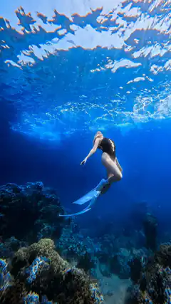 Woman diving underwater with fins