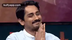 Man smiling with hands together
