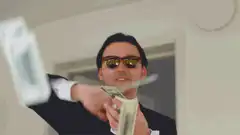 Man in sunglasses throwing money