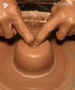 Hands shaping clay on pottery wheel