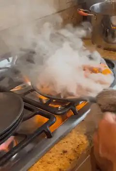 Shrimp and peppers flambéing in a pan
