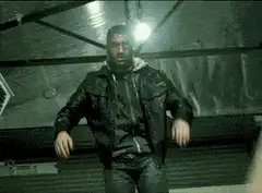 Man in black jacket dancing in garage