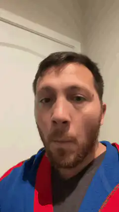 Man in blue and red hoodie looking around