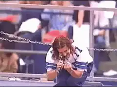 John Travolta singing at football game