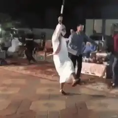 Man in thobe dancing with stick