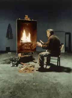 Man warming hands by painting of fire