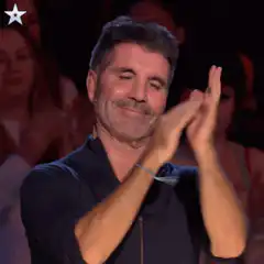 Simon Cowell clapping with a smirk
