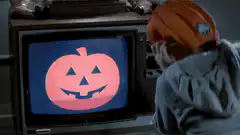 Person in pumpkin hat watching TV