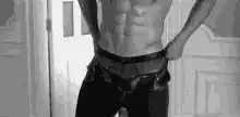 shirtless man pulling up jeans