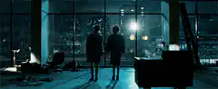 Two people watching explosions outside window