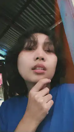 woman in blue shirt touching chin