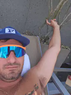 Man in sunglasses flexing arm