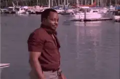 Man in red shirt smiling by marina