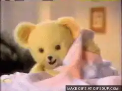 Teddy bear sleeping in bed