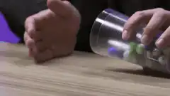 Person pouring marbles from a cup