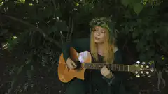 woman playing guitar in forest