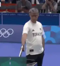 Shooting referee points gun at camera