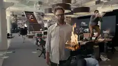 Seth Rogen holding flaming bread in office