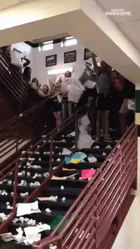 students throwing papers down stairs