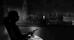 Woman in rocking chair points gun at ghost