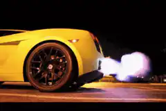 Yellow car backfiring at night