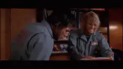 Two men in jumpsuits fight over a toaster