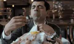 Mr. Bean eating a large meal