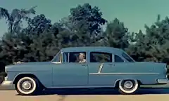 Man driving a light blue vintage car