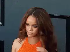 Rihanna waves and smiles