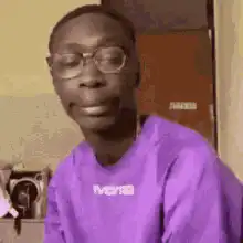 Man takes off glasses and looks at camera