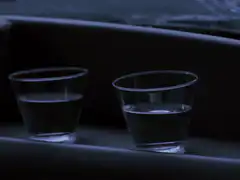 Two plastic cups of water in a car