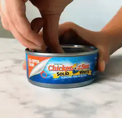 Hands opening a can of Chicken of the Sea tuna