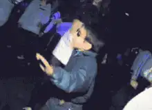 Kid dancing with sunglasses at a club