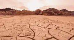 Cracked desert ground with mountains