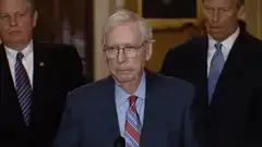 Mitch McConnell shakes hands at podium