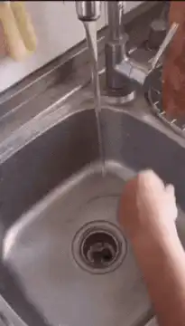 Hand deflecting water stream with spoon