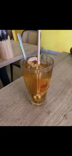 Iced tea with ice and straw on wooden table