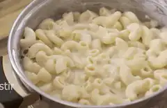 Stirring creamy macaroni and cheese