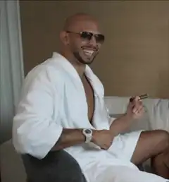 Man in bathrobe laughing with cigar