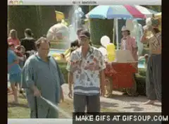 Two men watch a boy get sprayed by a hose