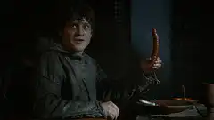 Ramsay Bolton holding a sausage