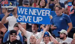 Fan holding We Never Give Up sign