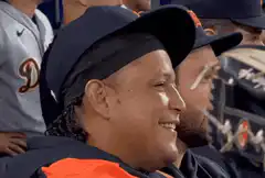 Man in baseball cap smiling and closing eyes